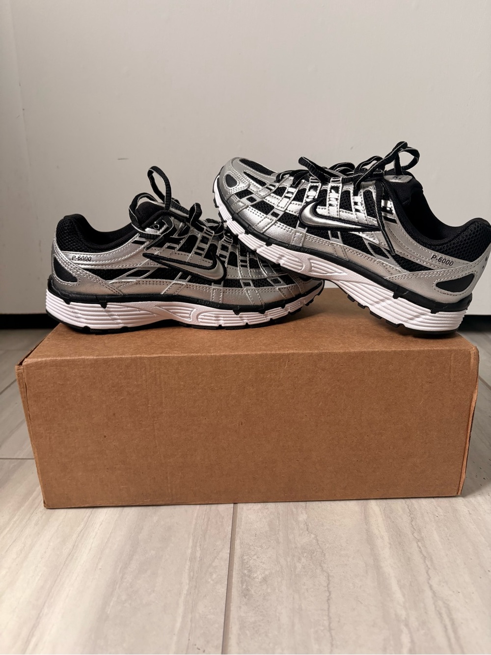 W Nike P-6000 sneakers feature a striking metallic silver and black color way
